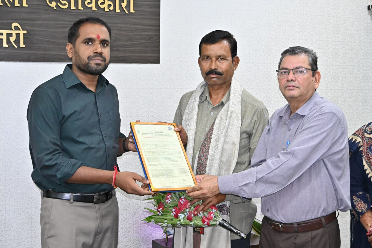 धमतरी के किसान बंसी लाल सोरी को चिरपोटी टमाटर के संरक्षण के लिए सम्मानित करते कलेक्टर